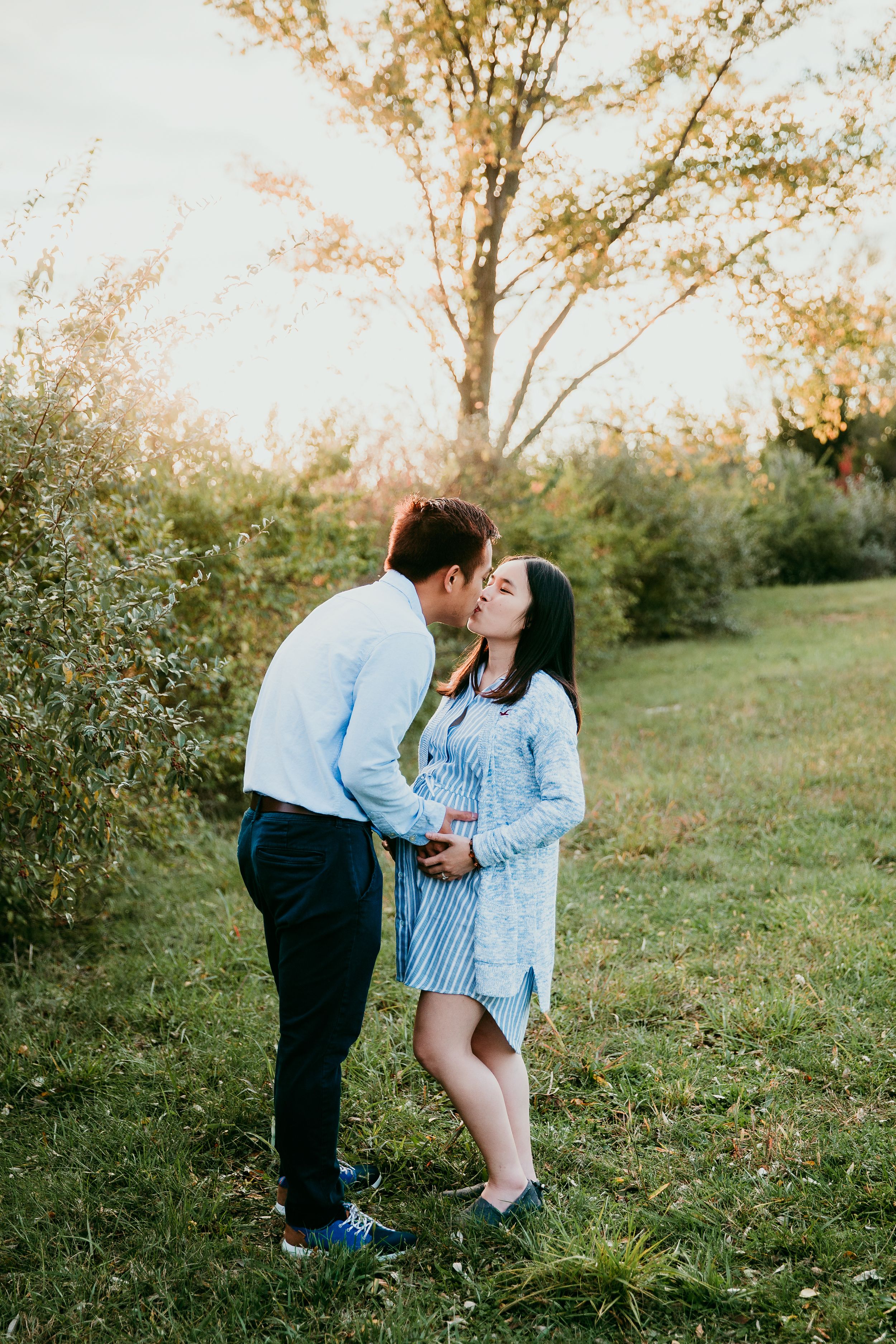 couple kissing and holding woman's belly