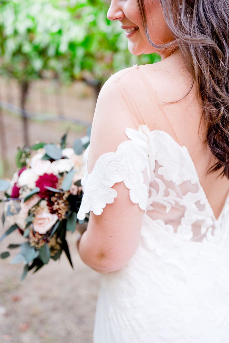 bride's lace wedding sleeve and red wedding flowers