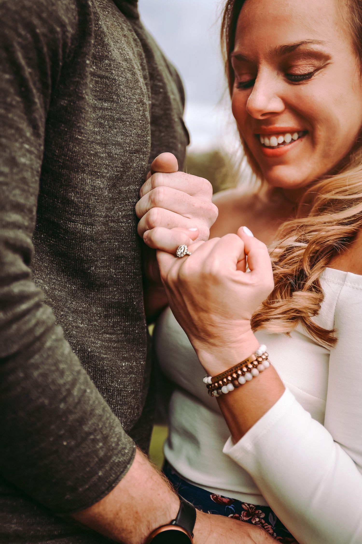 A tender moment captured between two people holding hands with a joyful expression.