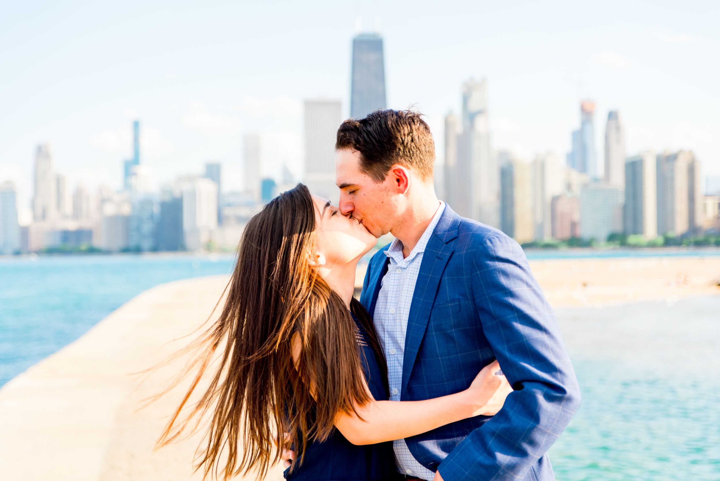 man and woman kissing in front of Hancock tower after North Avenue Beach proposal