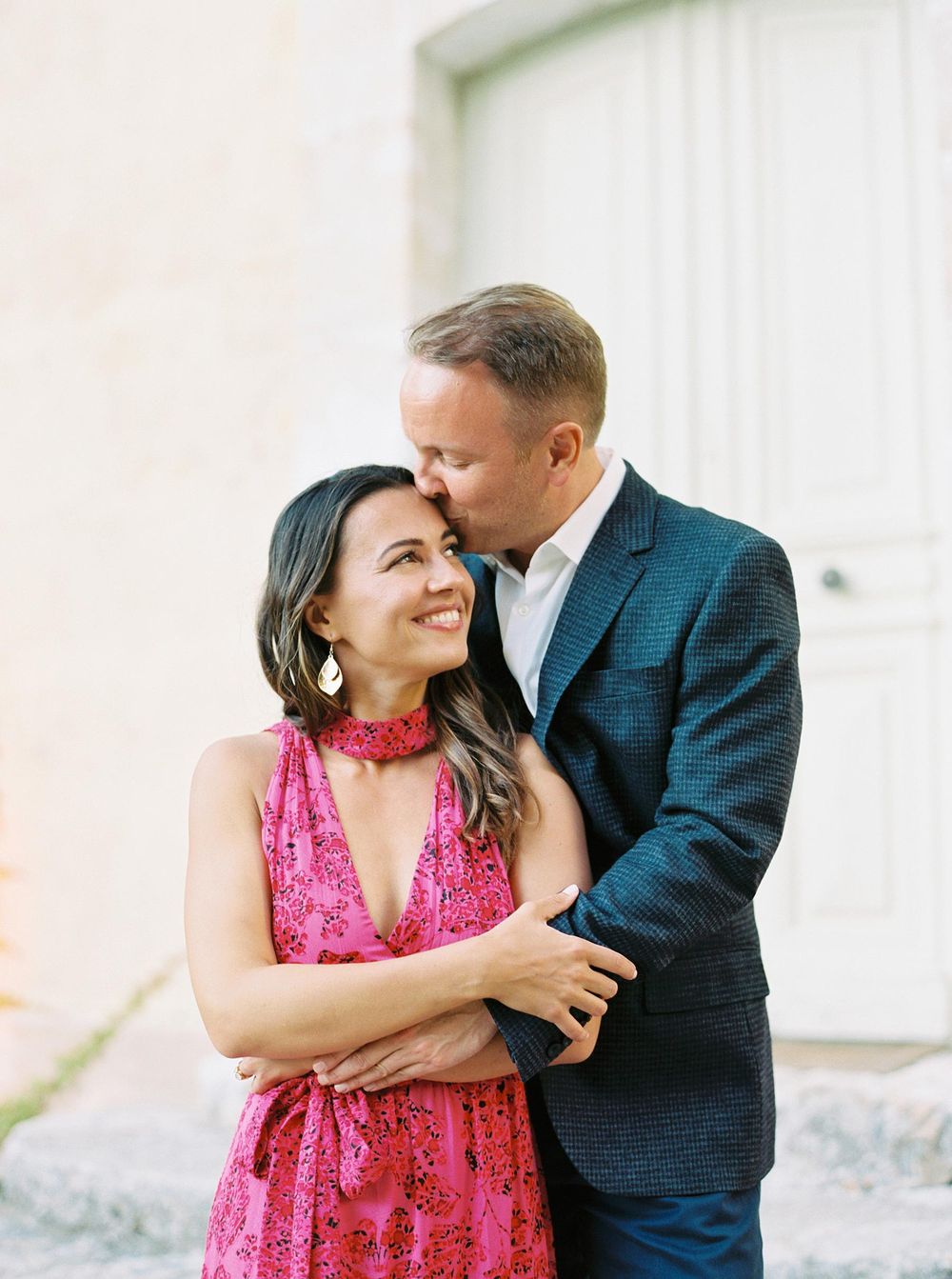 A bride and groom smiling together in front of a door at La Bastide de Ganay, Provence.