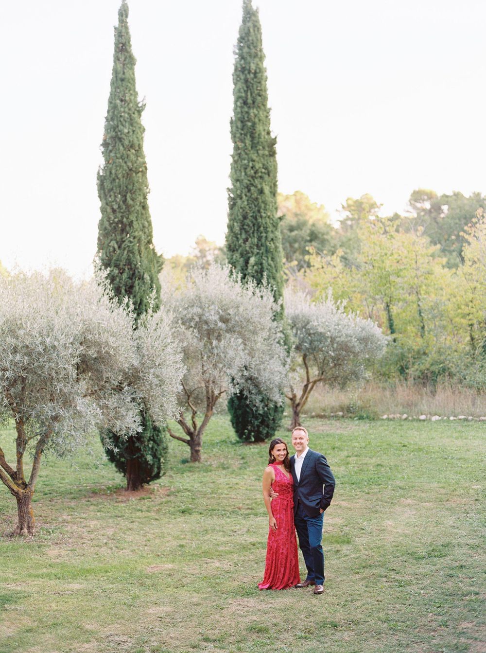 A bride and groom stand amidst olive trees at La Bastide de Ganay, Provence, creating a picturesque scene.