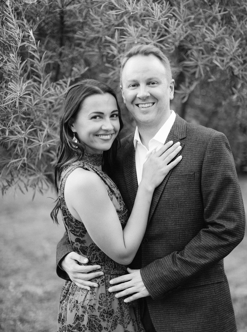 An artistic black and white photograph featuring a couple, the bride and groom, posing gracefully.