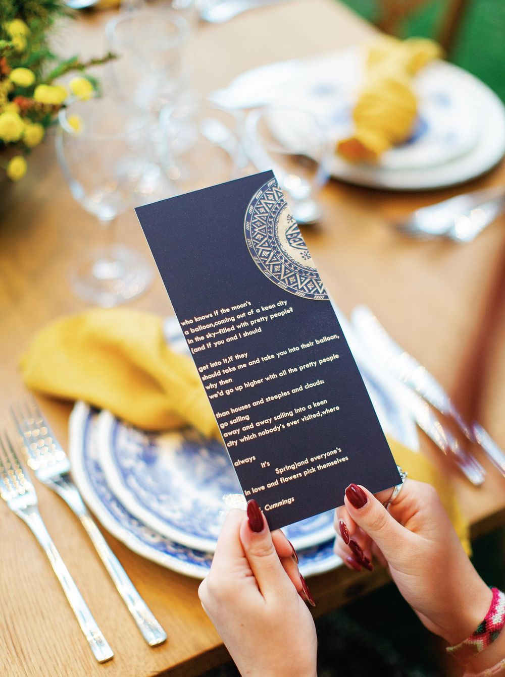 A person sitting at a table, holding a menu, ready to make a selection from the available options.