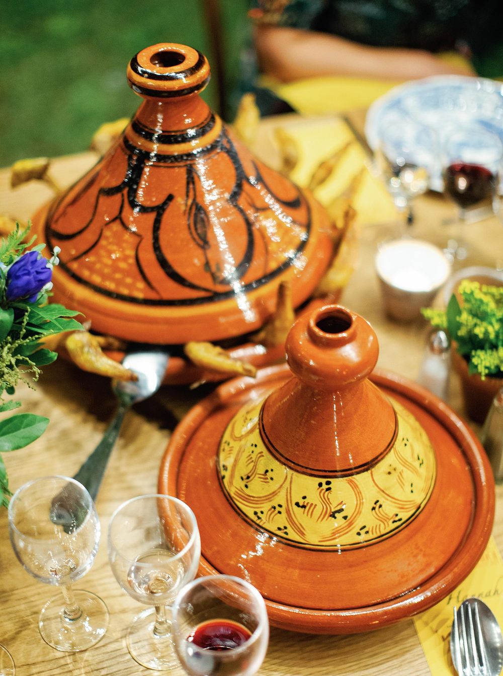 A beautifully arranged table with Moroccan tagine, dishes, and glasses.