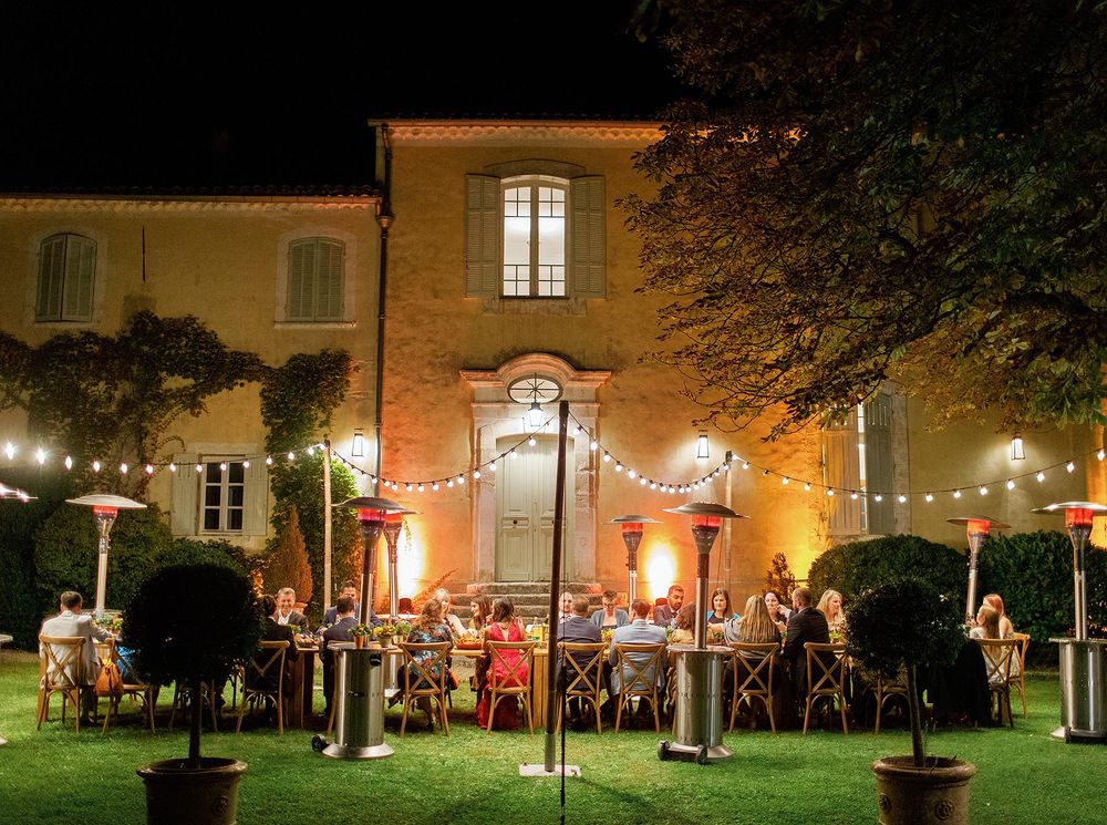 Scenic outdoor gathering in Provence: guests seated at tables, enjoying a welcome dinner at La Bastide de Ganay.