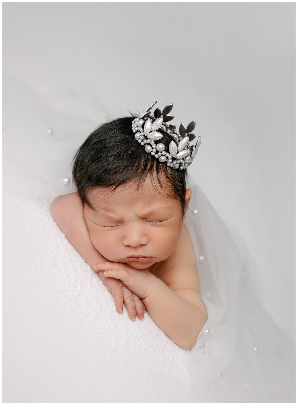 ausitn newborn photography baby posed chin on hands wearing pearl crown baby princess on white austin baby photos