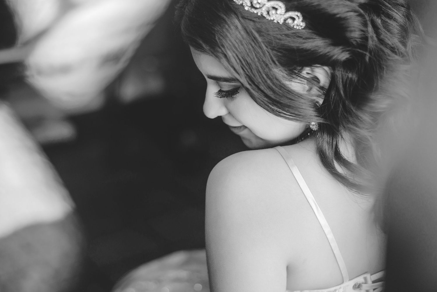 A black and white profile shot of an elegant bride wearing a delicate hairpiece.