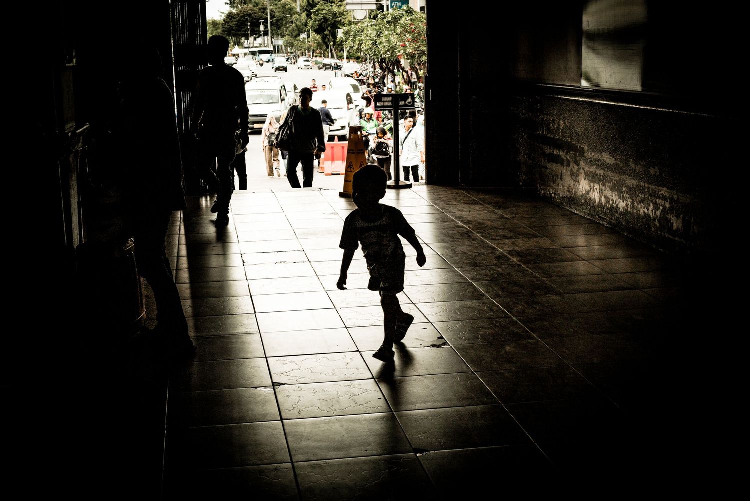 Young child silhouetted playing in Jakarta Kota train station, Jakarta Indonesia