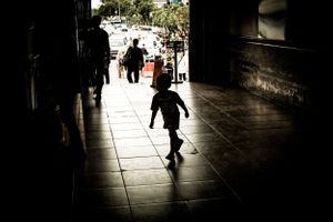 Young child silhouetted playing in Jakarta Kota train station, Jakarta Indonesia