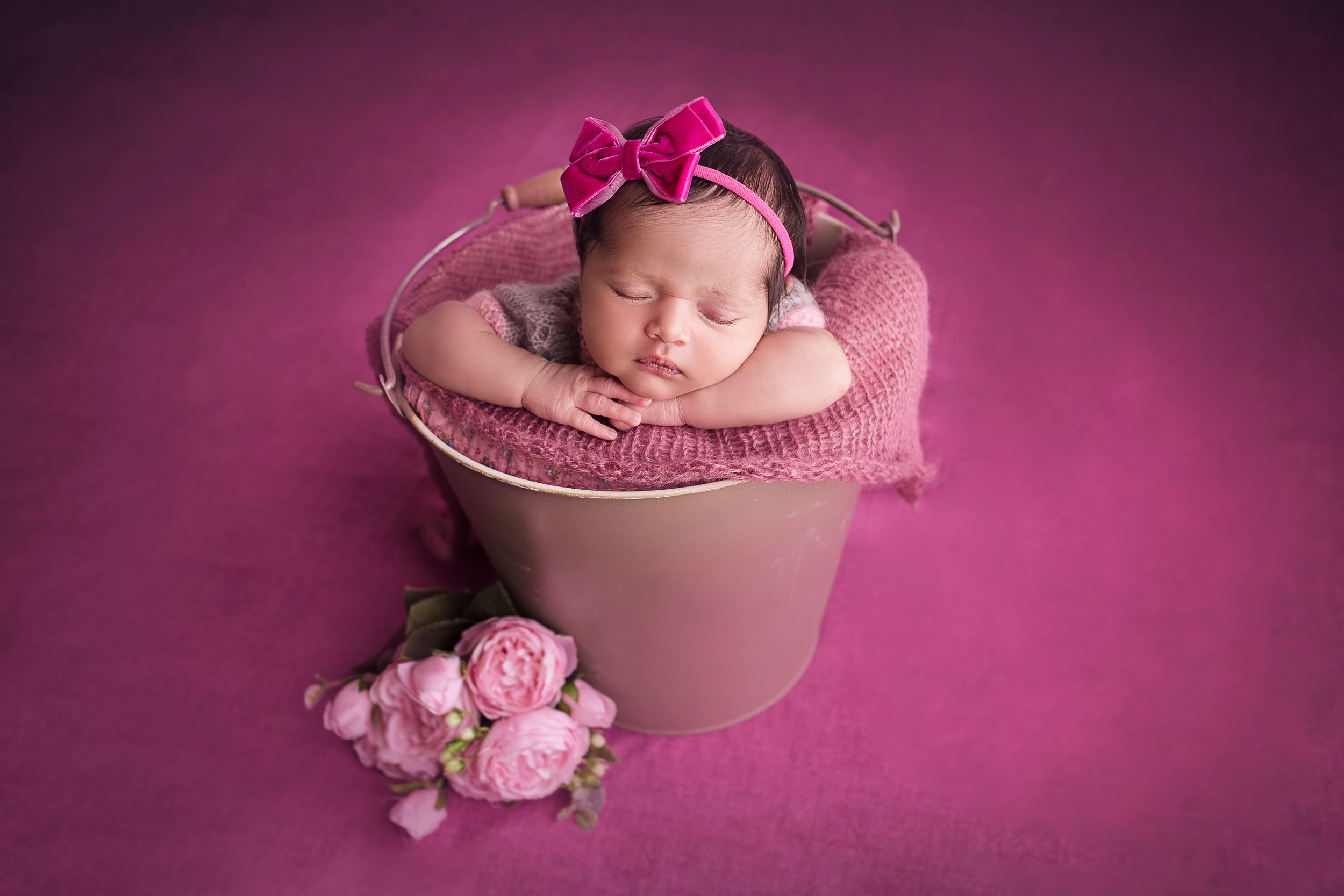 Newborn Baby posing inside a bucket Fushia color