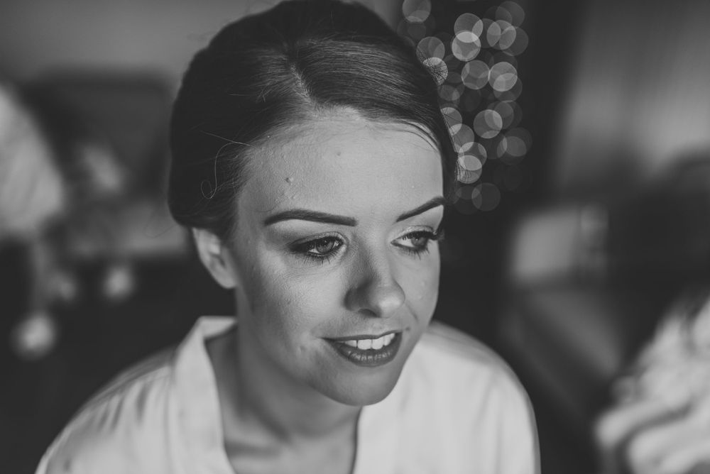 Black and white picture with the bride getting the finishing touches to her makeup.