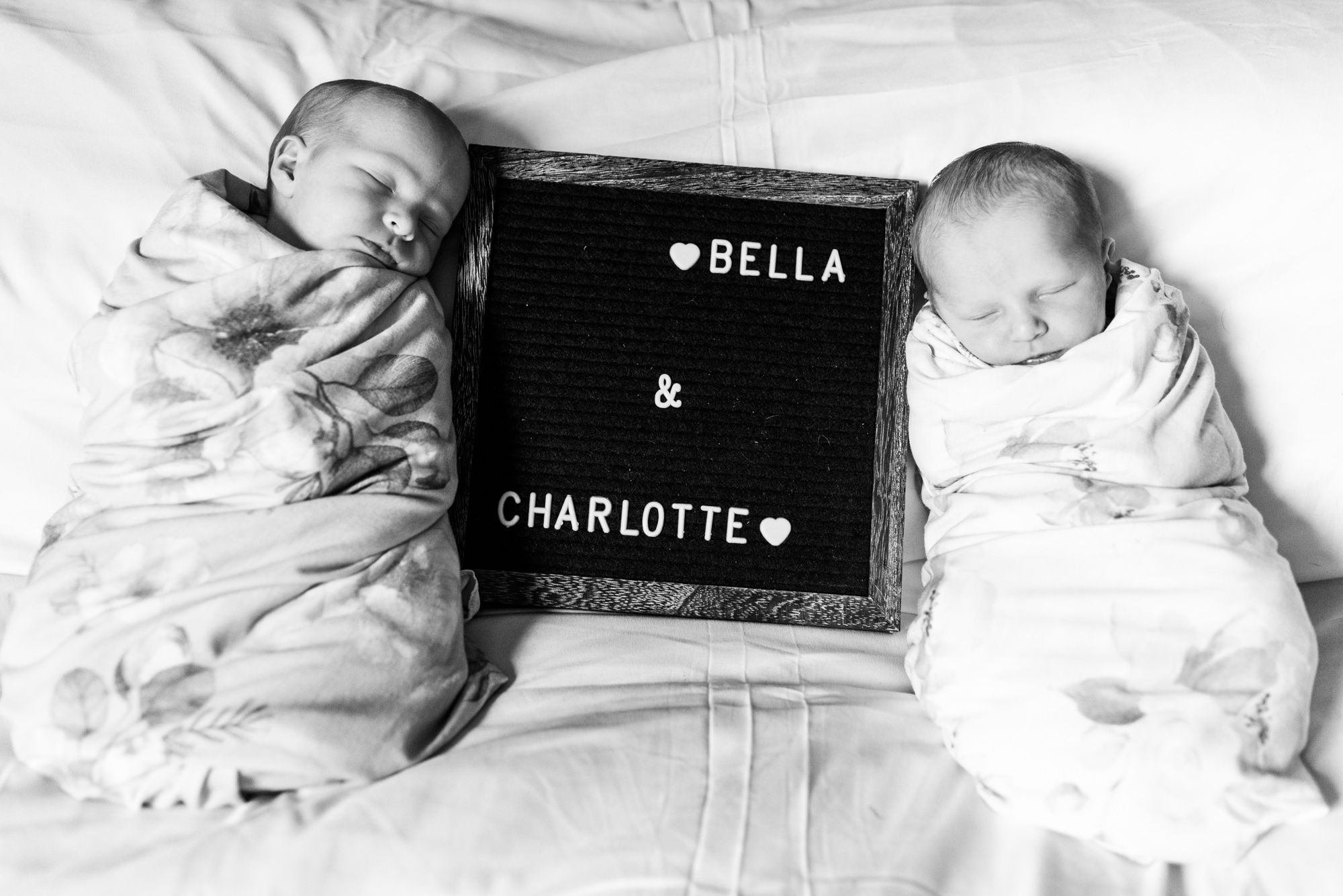 Newborn twin girls sleeping with name sign in Corsica, Pennsylvania