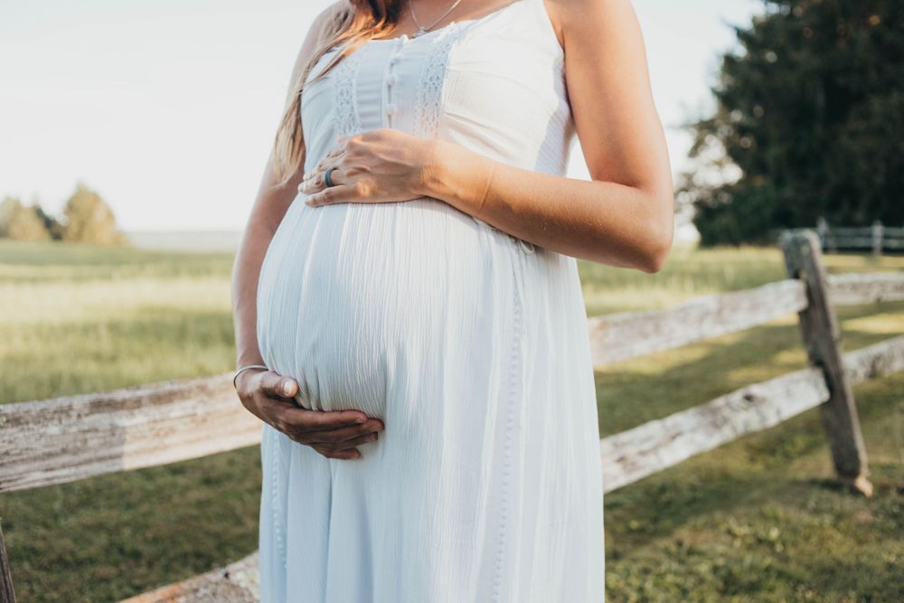 mom cradling her belly by worcester ma maternity and newborn photographer
