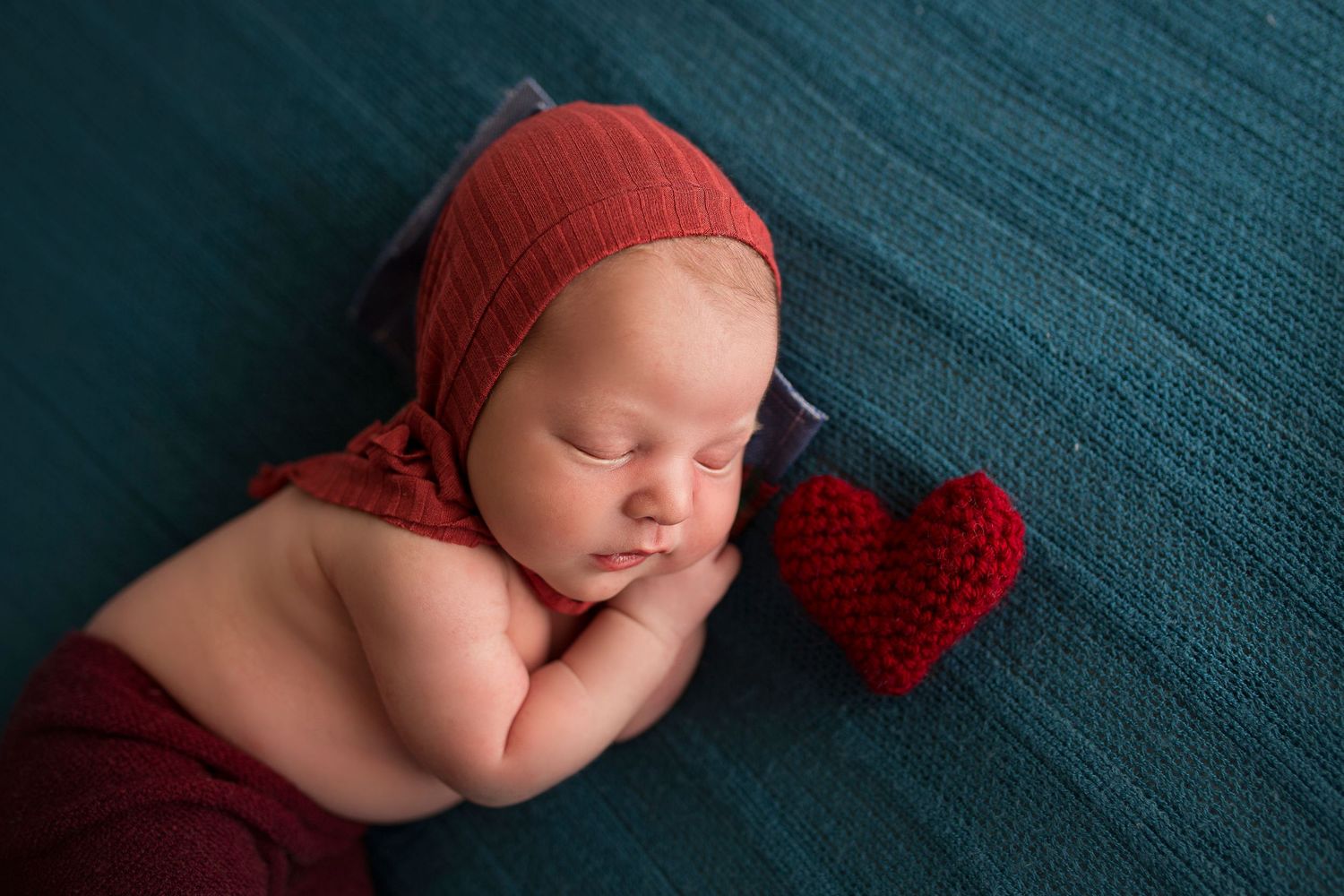baby boy dressed in red with a knit heart