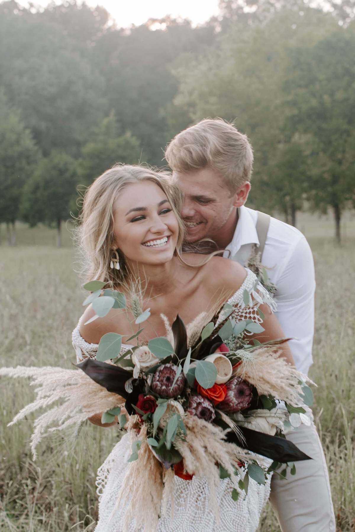 destination wedding adventure elopement newlyweds laughing with husband hugging wife behind. Audrey Darke Photographer