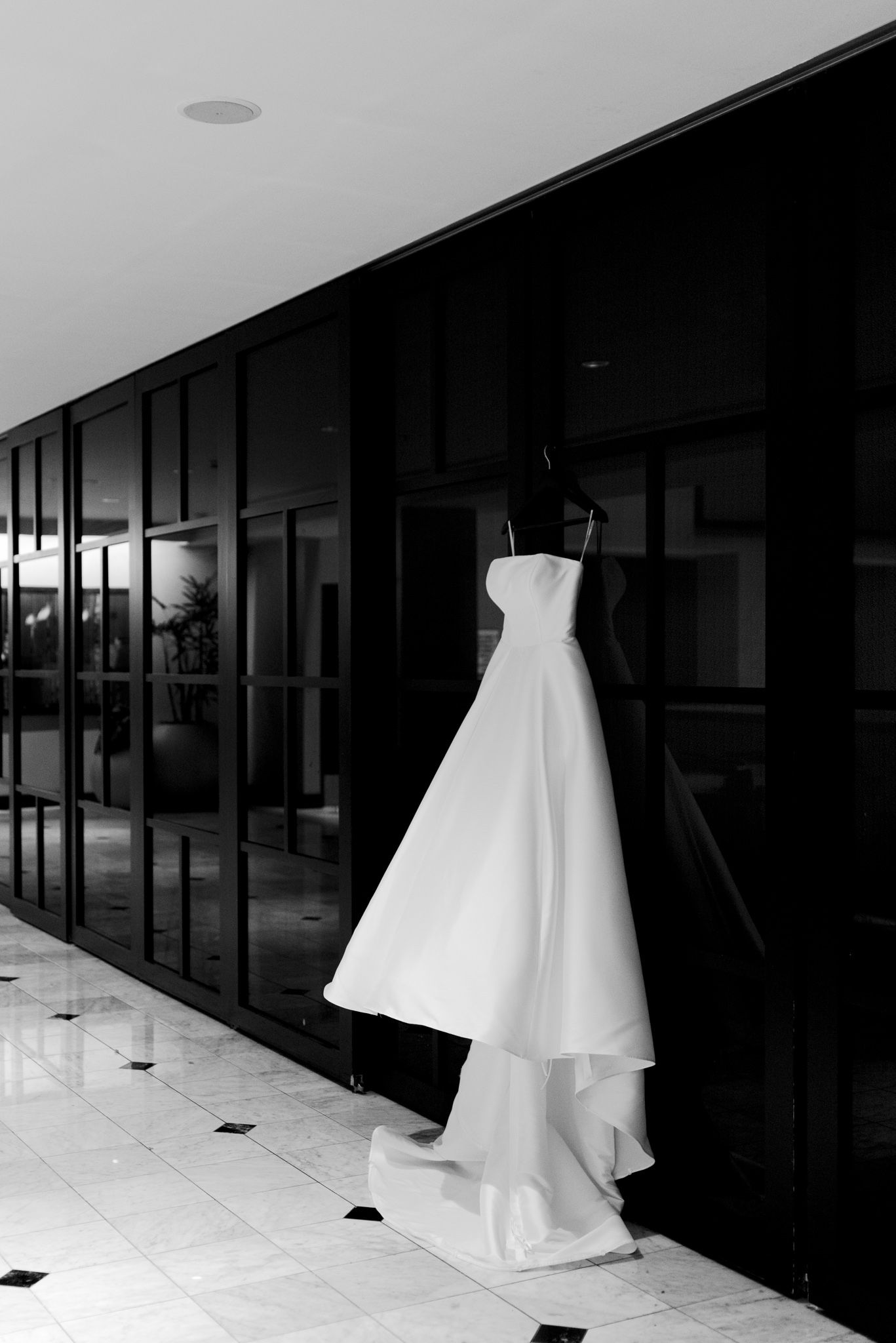 strapless wedding dress hanging on black doors for downtown St. Louis wedding