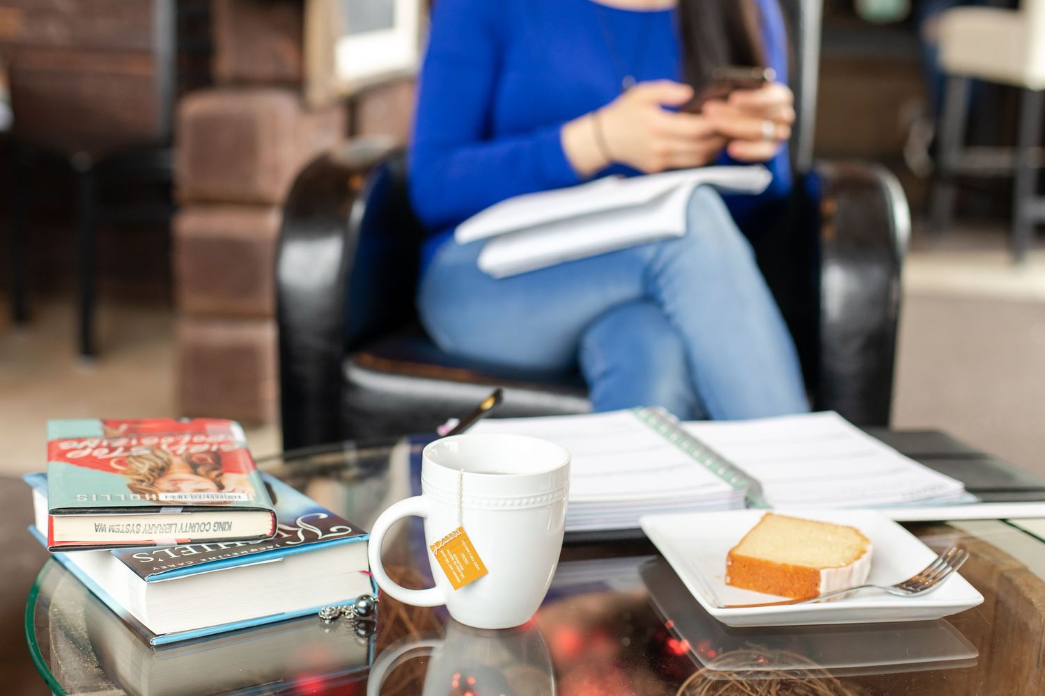 Lifestyle branding session in cafe with tea books and cake female business owner working on phone in Maple Valley, WA