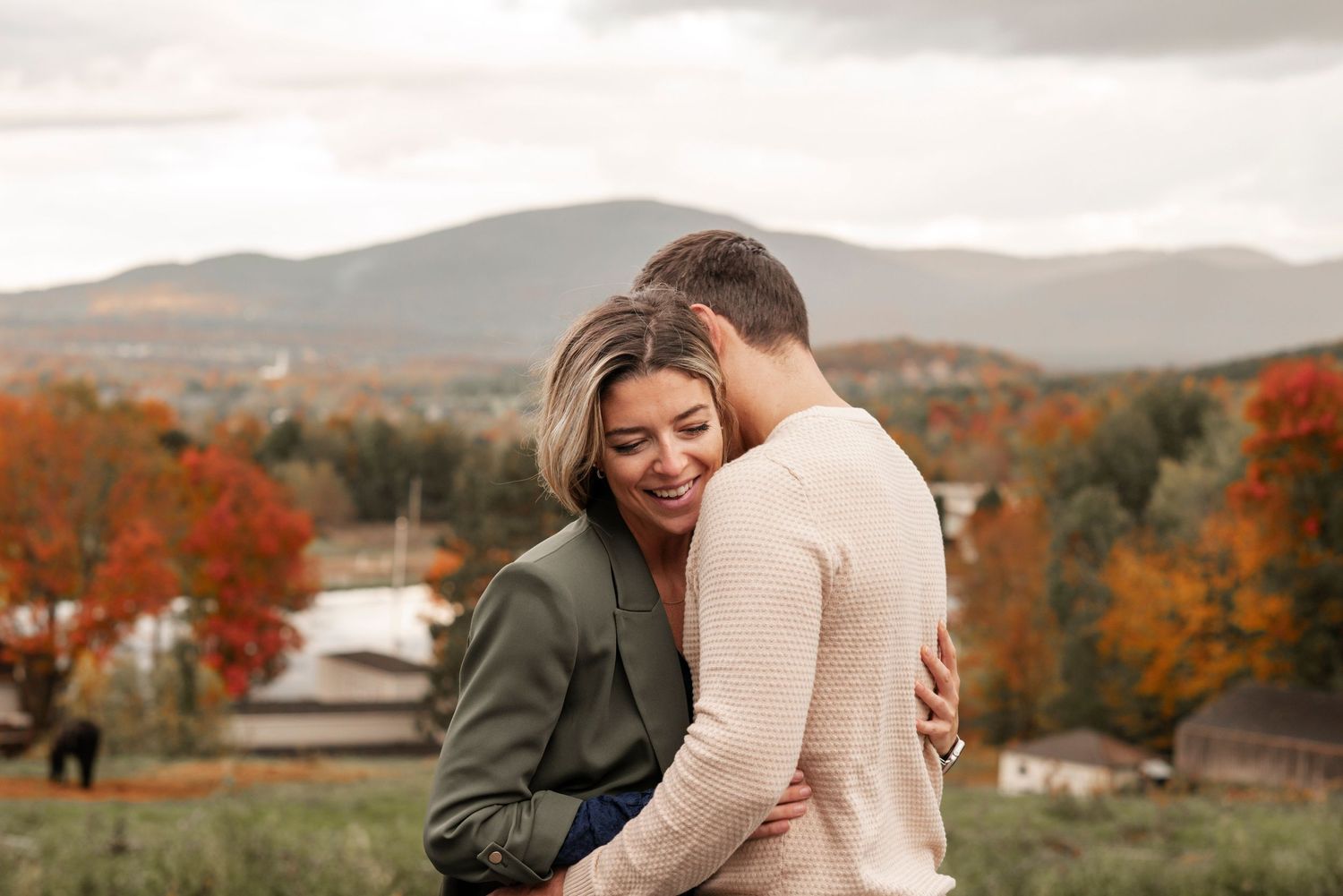 Romantic autumn engagement photos with warm fall colors in a scenic mountain landscape.