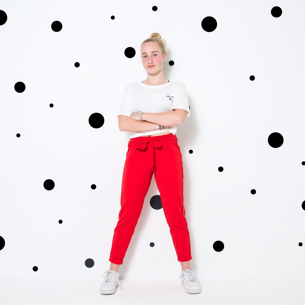 Meisje met rode broek in de fotostudio