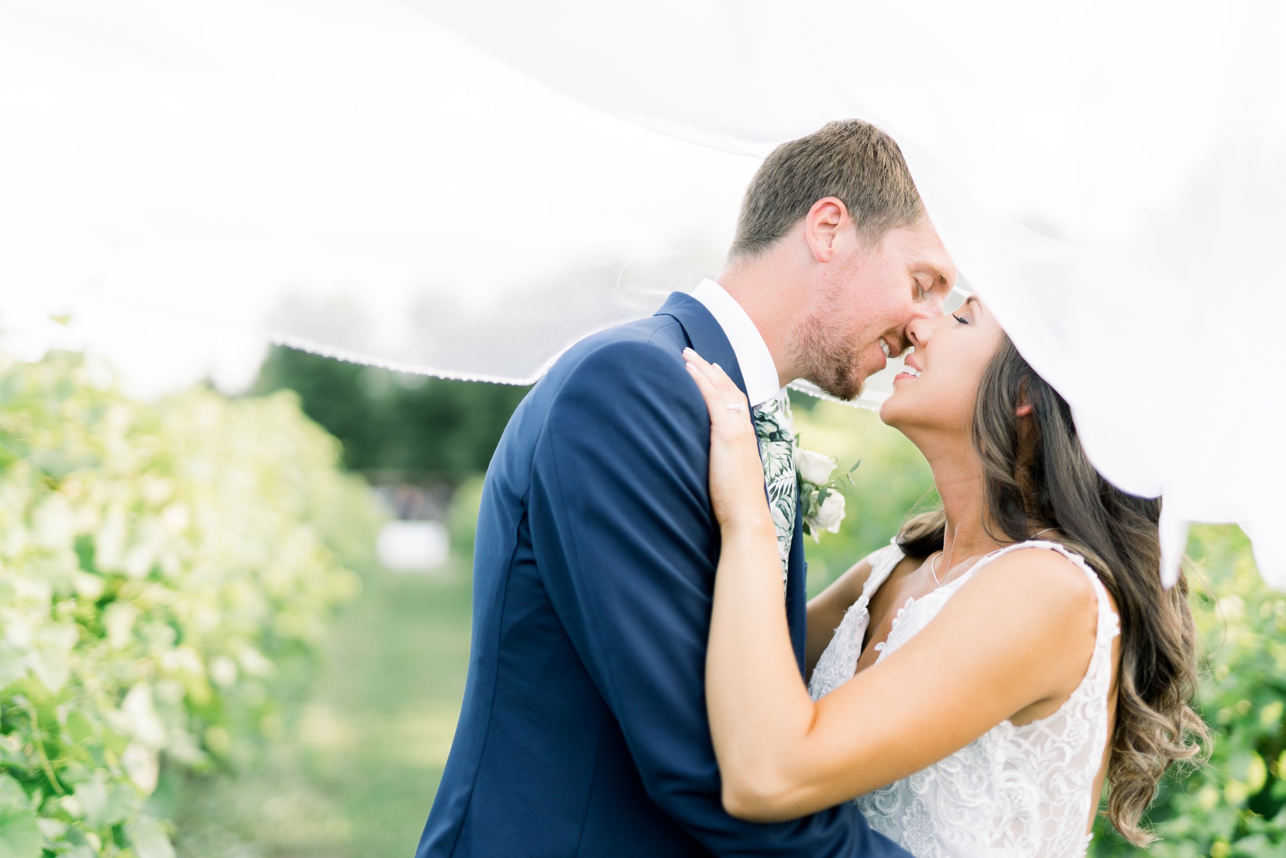 Vineyard photos with veil kissing at Prairie Moon Winery wedding in Ames, Iowa