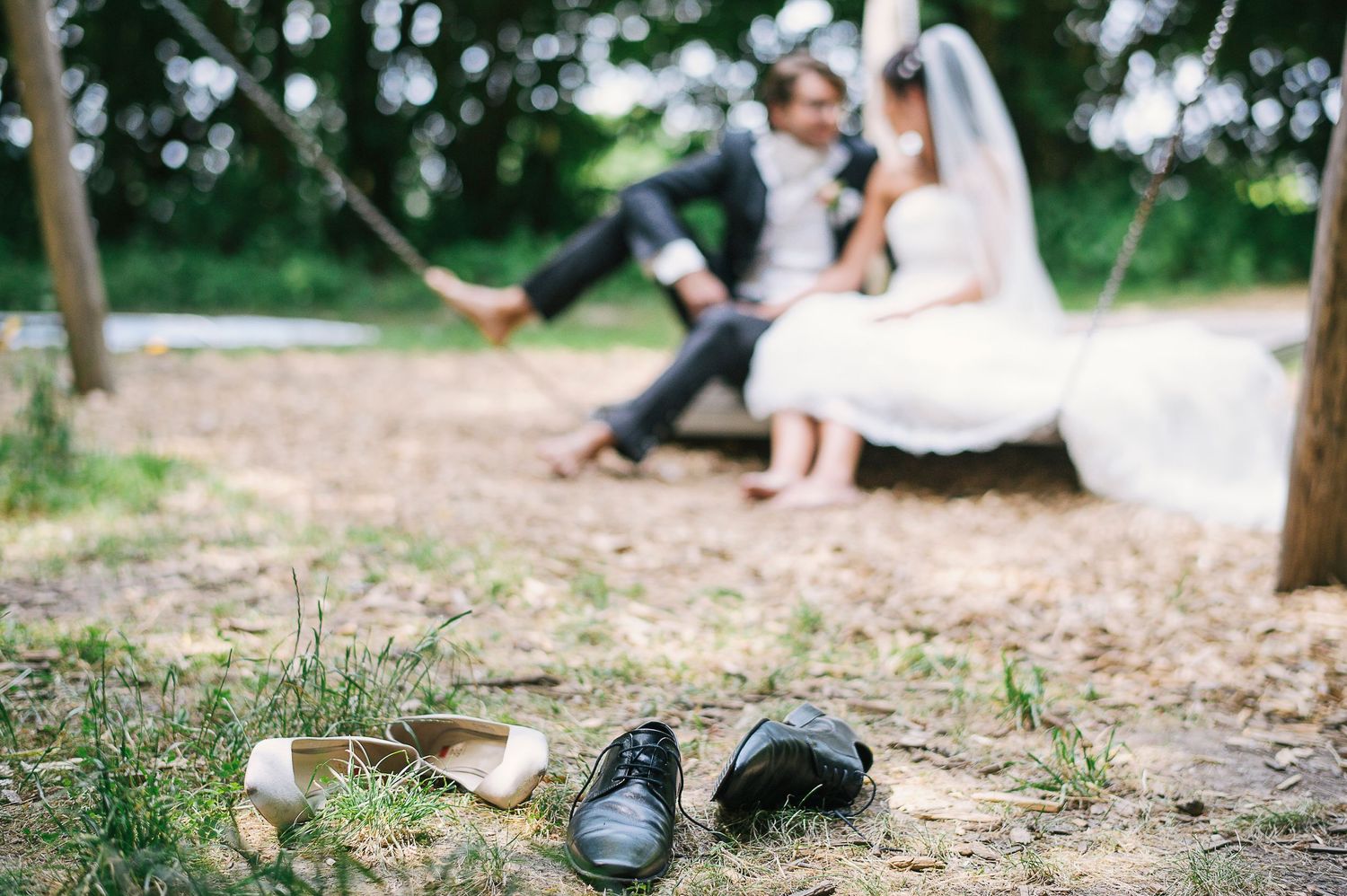 Schuhe des Brautpaares im Vordergrund - Brautpaar auf Hängematte unscharf im Hintergrud - Hochzeitsfotograf Regensburg