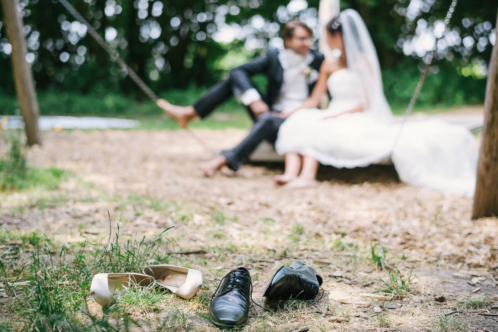 Schuhe des Brautpaares im Vordergrund - Brautpaar auf Hängematte unscharf im Hintergrud - Hochzeitsfotograf Regensburg