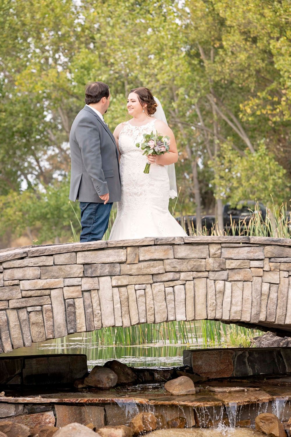 Bride and groom looking at each other on a bridge at Fallen Oaks Estate