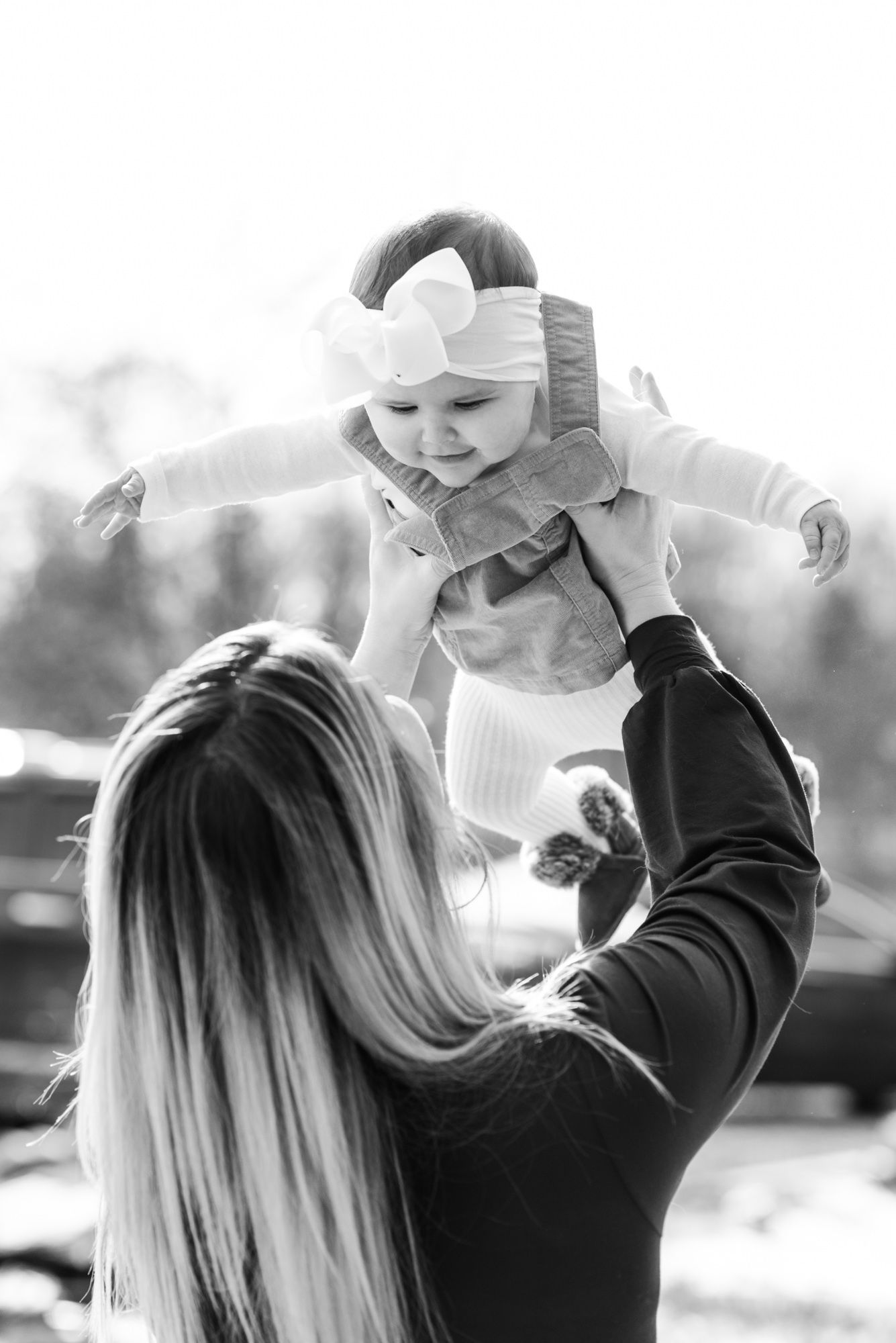 Lifestyle family photoshoot with mom holding baby in the air in Gibsonia, Pennsylvania
