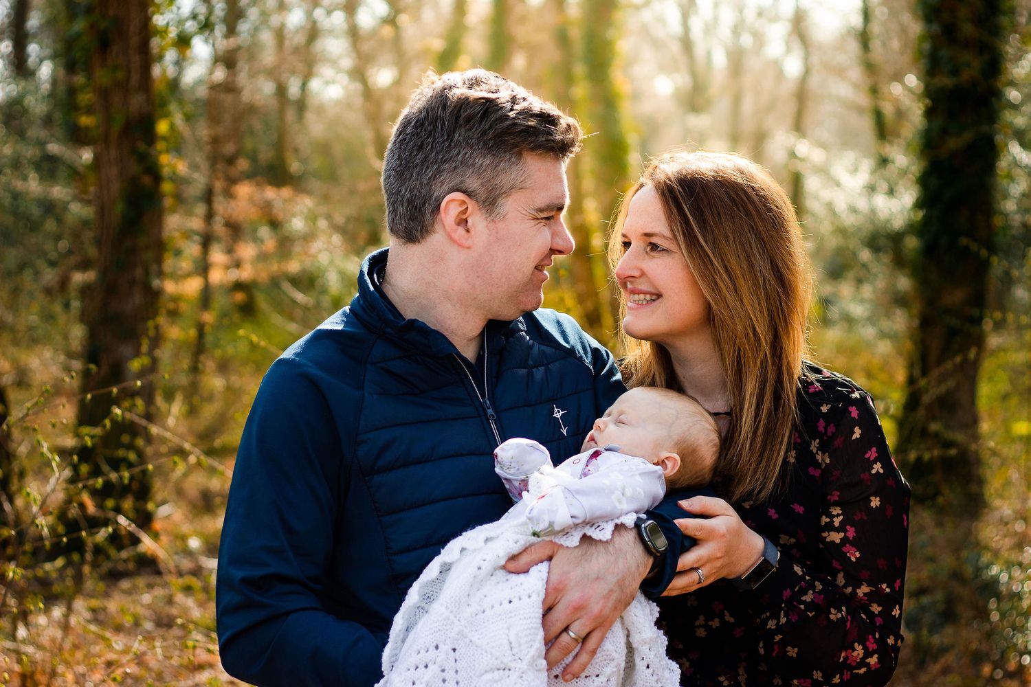 At Staunton Country Park in Havant, Hampshire a new Mum and Dad hold their newborn daughter and smile at each other.
