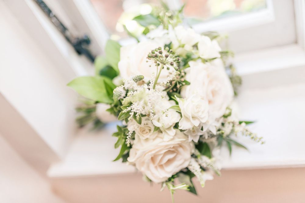 Soft focus bridal bouquet with white roses and delicate baby's breath flowers.