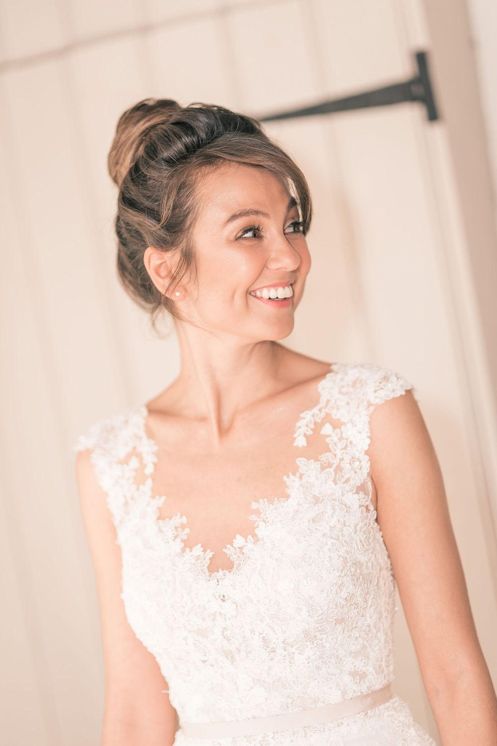 Close up portrait of bride with elegant updo and lace neckline.