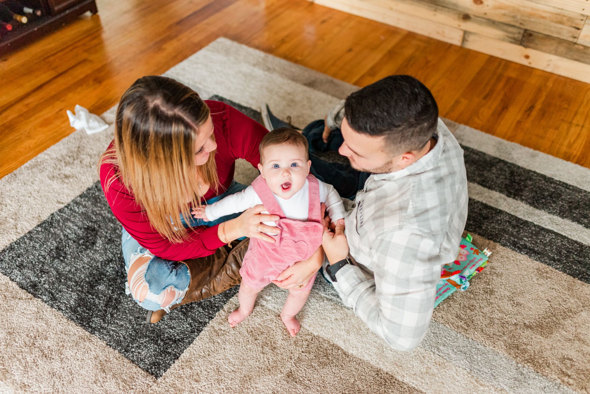 Lifestyle family photoshoot in the home with mom and dad on floor with 6 month old baby in Gibsonia, Pennsylvania