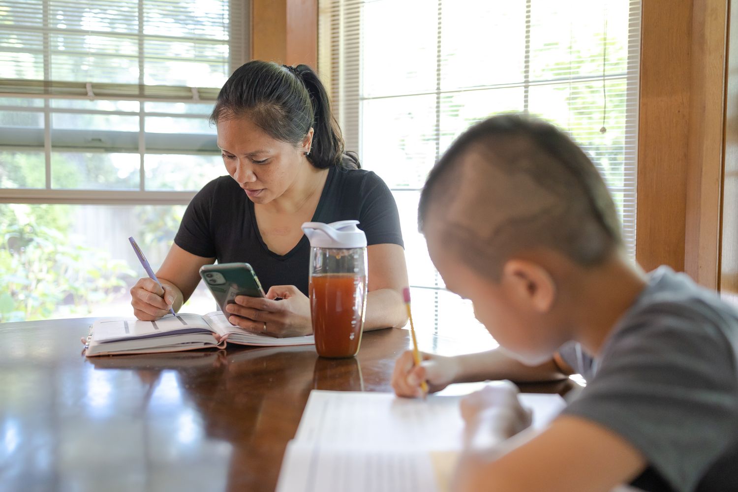 mom and son working at table on homework and business Homeschooling entrepreneur mom Maple Valley, WA branding photo