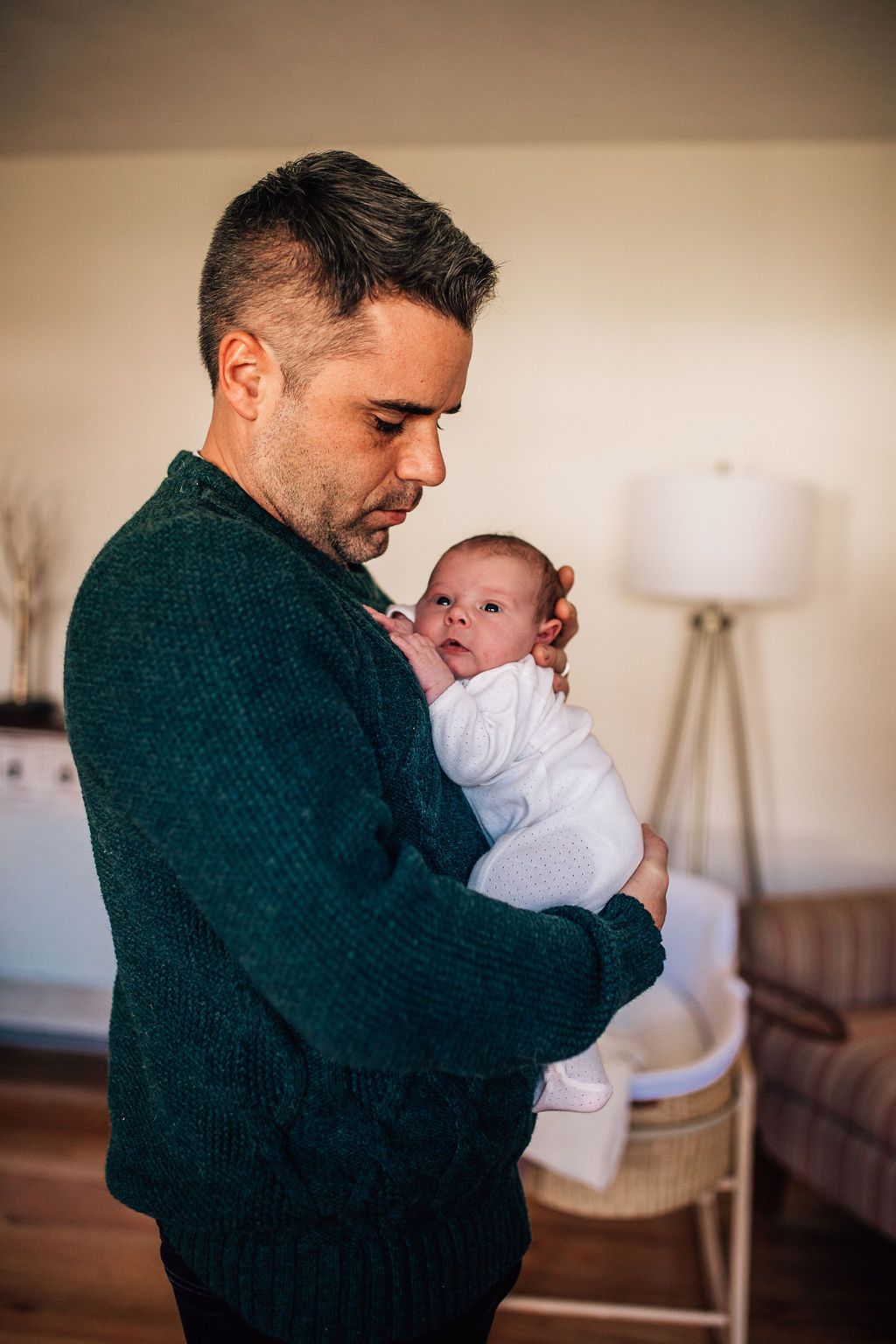 dad holding his baby up to his chest