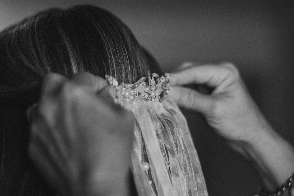 Detail wedding photography of mother pinning in the bride's veil into her hair