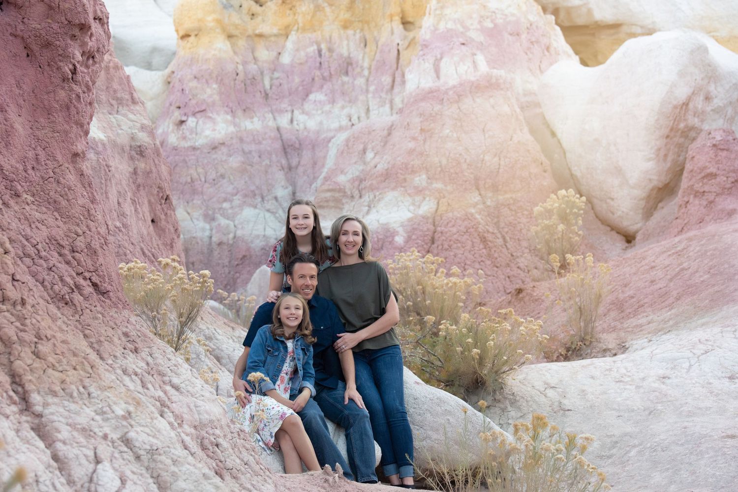 Family of 4 with 2 preteens posed in front of beautiful rock formations