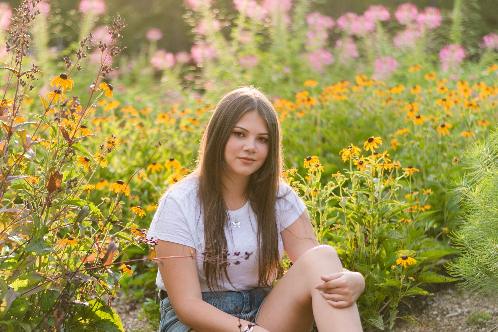 Girl sitting in flowers in golden sunlight at Hartwood Acres in Pittsburgh Pennsylvania