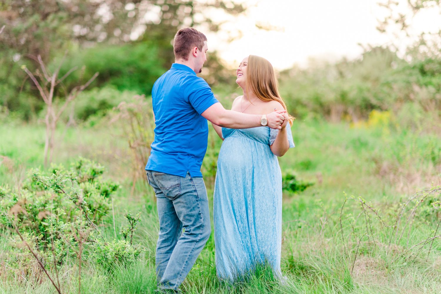 Maternity session with couple dancing in field in golden hour sunlight at Moraine State Park, Pennsylvania