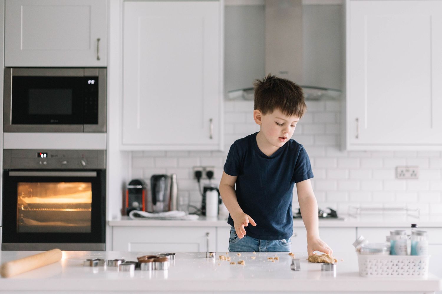little boy cutting shapes with cookie cutter