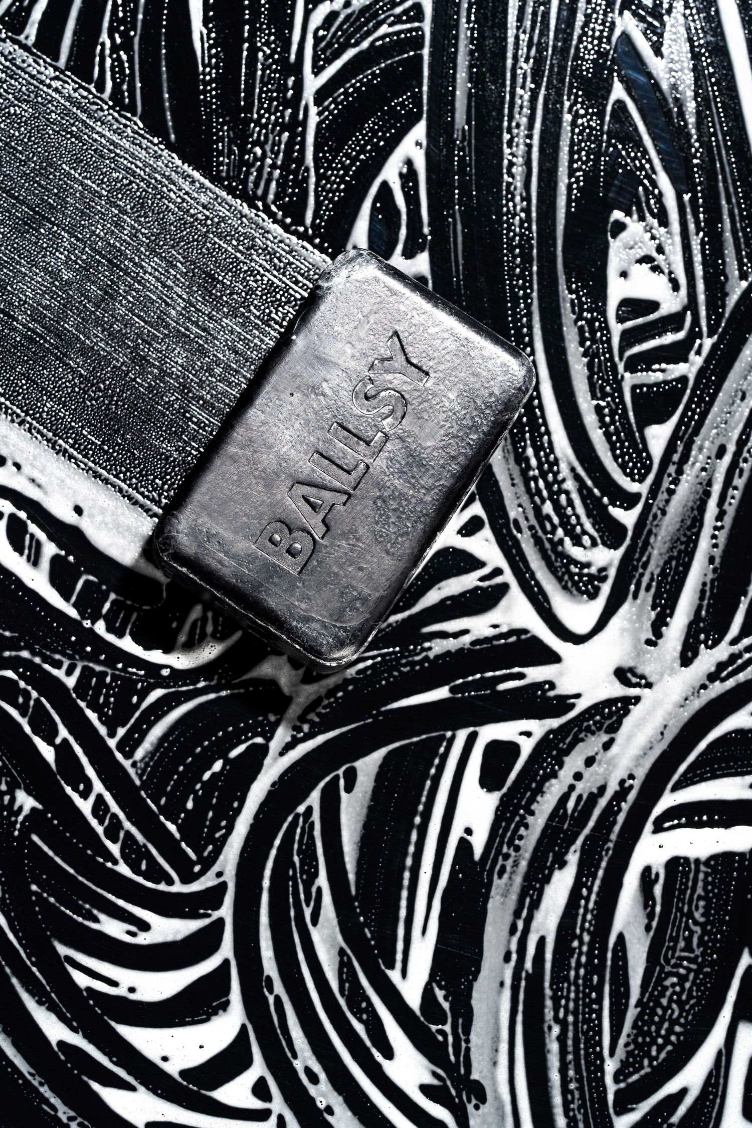 Close-up of a Bally silver buckle on dark patterned leather.