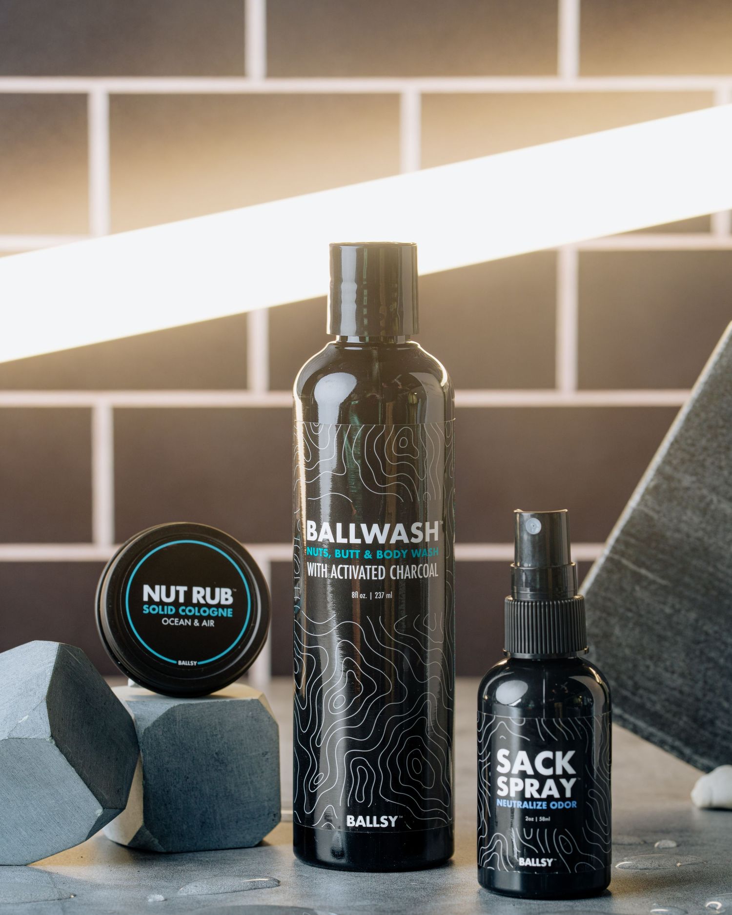 Black Ballwash bottle with nut rub container and sack spray against tiled background.