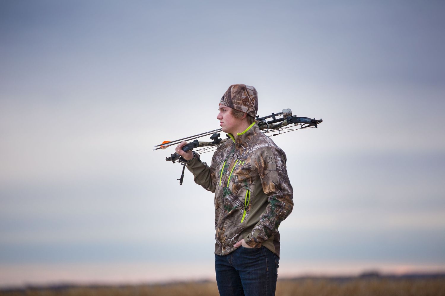 teenage boy in field with boy hunting gear
