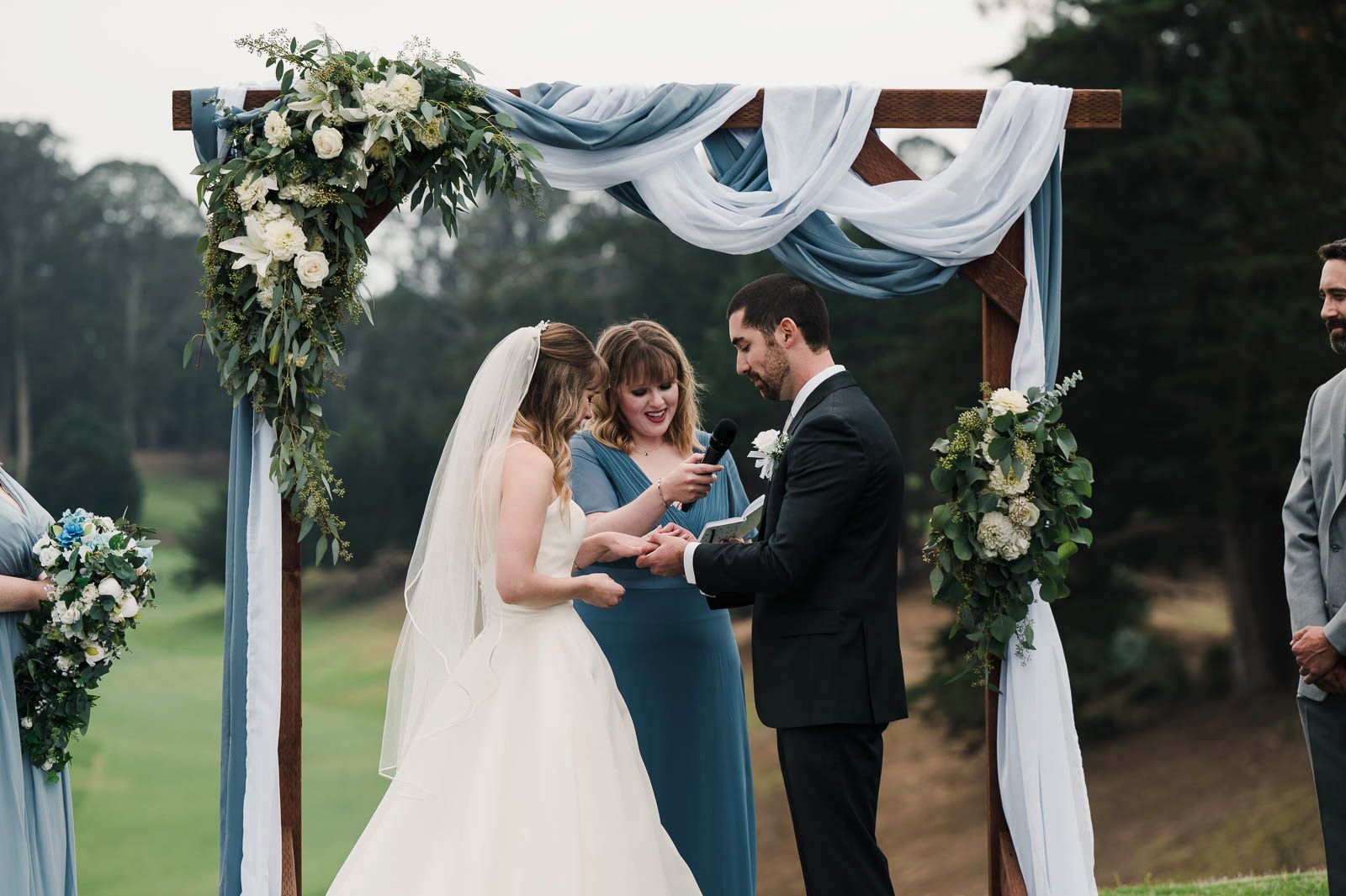 groom placing a ring on the brides finger
