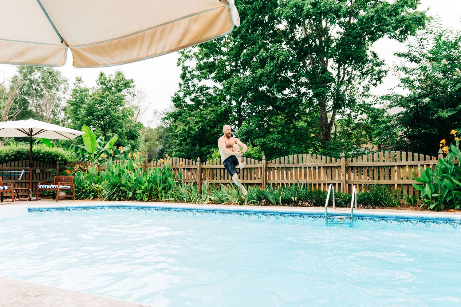 Dad jumping into his pool