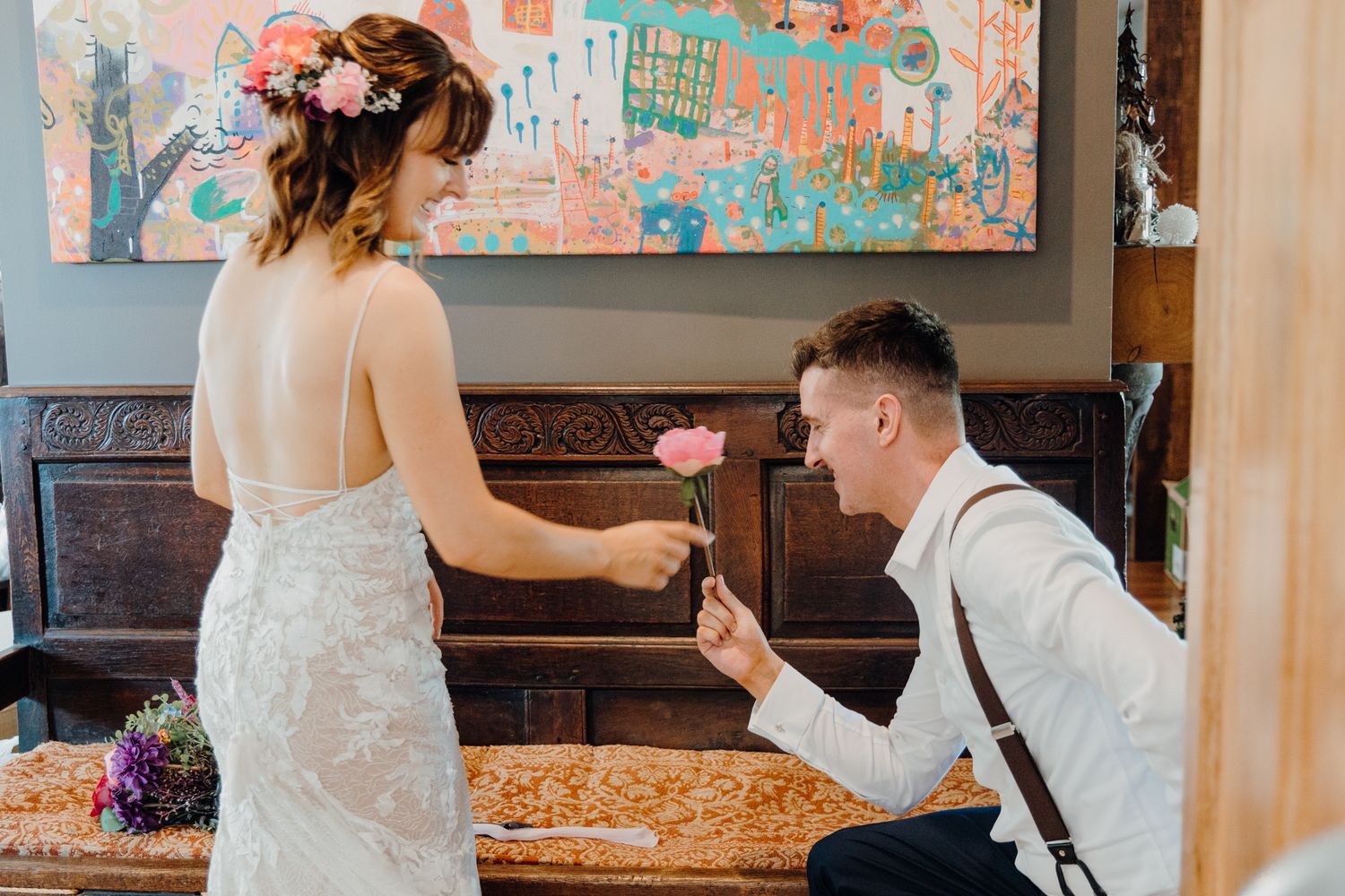 An intimate moment shared in front of a colorful abstract painting.