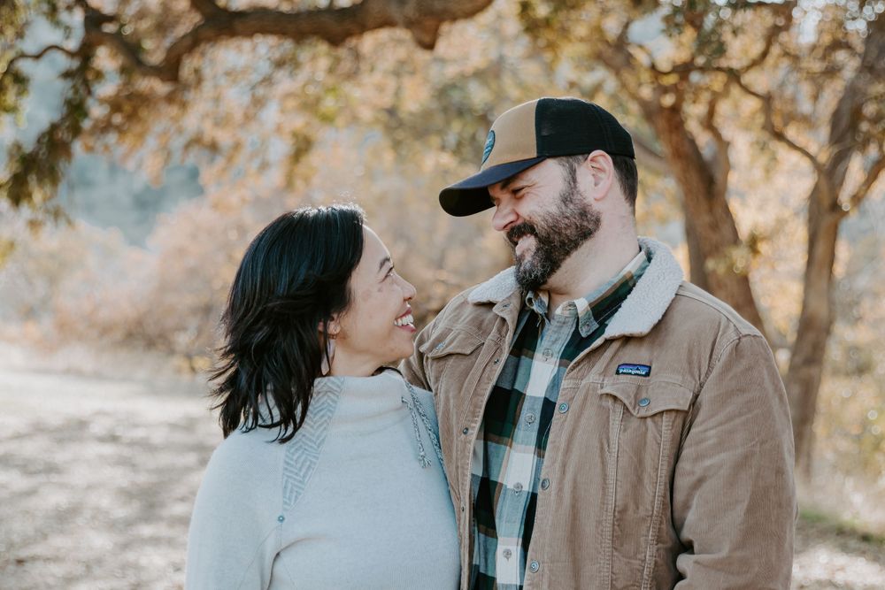 Couple sharing a loving moment while standing on a nature trail.