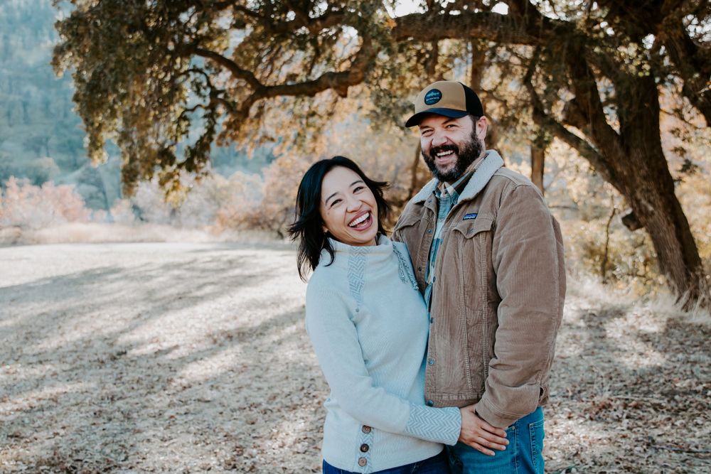 Couple embracing and laughing together on an outdoor trail.