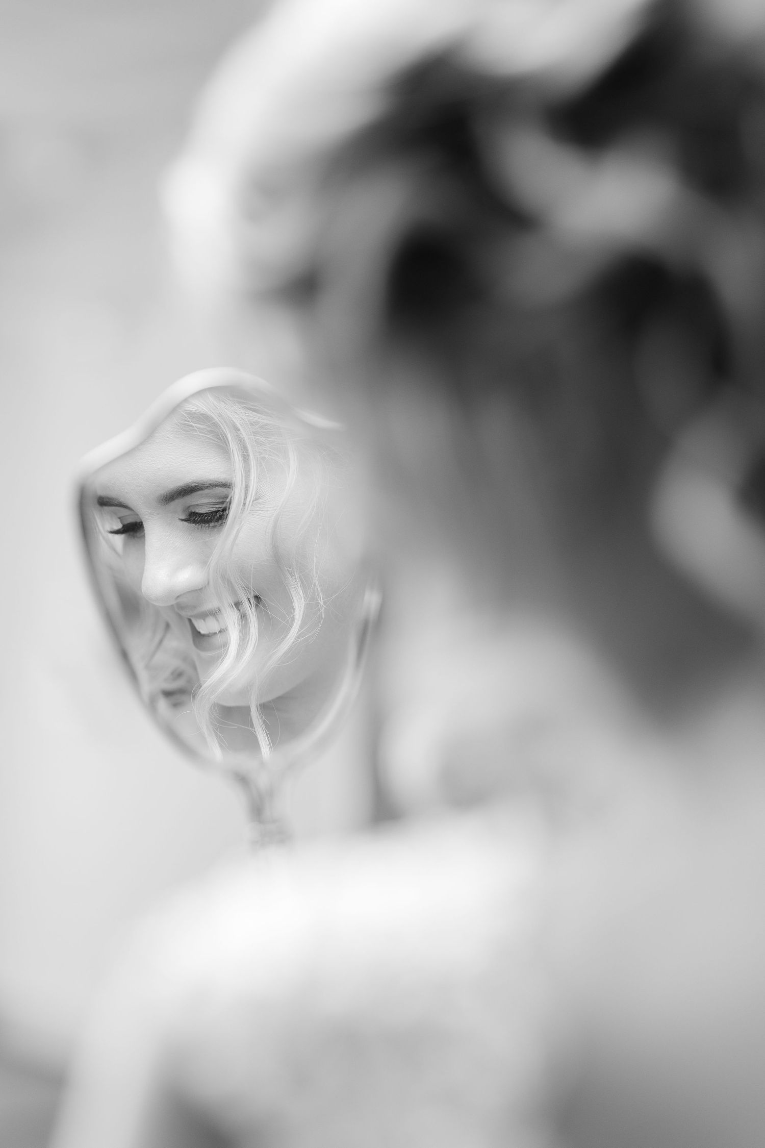 Bride softly smiling into mirror