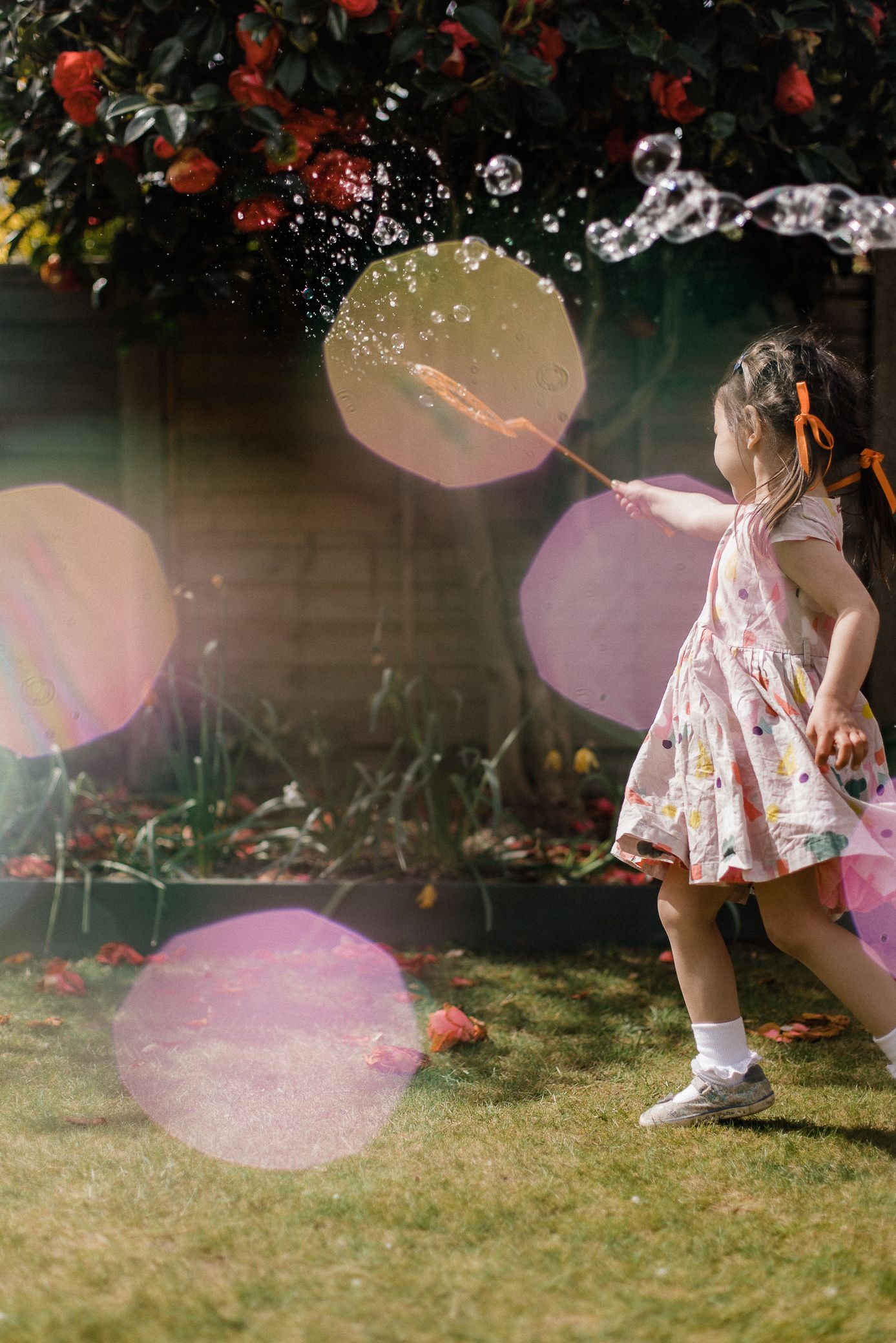 Artistic photo of little girl playing with bubbles